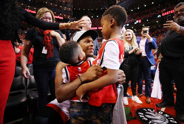 Kyle Lowry celebrates with his sons, Kameron and Karter, after defeating the Milwaukee Bucks 100-94 in Game 6 of the NBA's Eastern Conference finals on May 25.