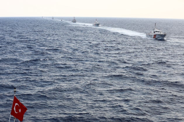 A Urkey national flag waves as Turkish soldiers take part in a military search and rescue exercise with helicopters and ships near Magosa, Cyprus, on June 12, 2019. -