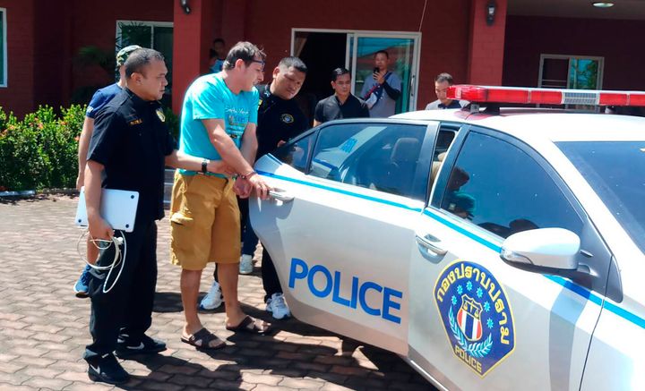 Italian Francesco Galdeli, in handcuffs, was arrested by Thai police officers at a house in Chonburi 