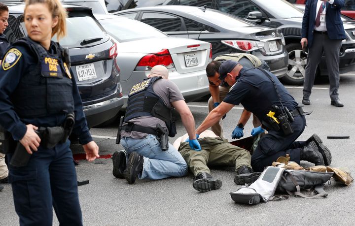 Law enforcement officers attend to an injured shooter in a parking lot after he fired shots at the Earle Cabell Federal Building in downtown Dallas, Monday, June 17, 2019.