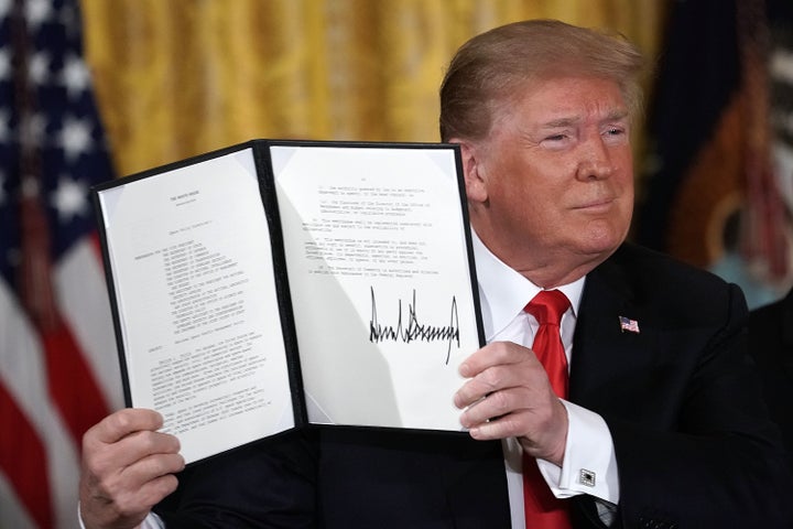 U.S. President Donald Trump holds up an executive order that he signed during a meeting of the National Space Council at the East Room of the White House June 18, 2018, in Washington, D.C.