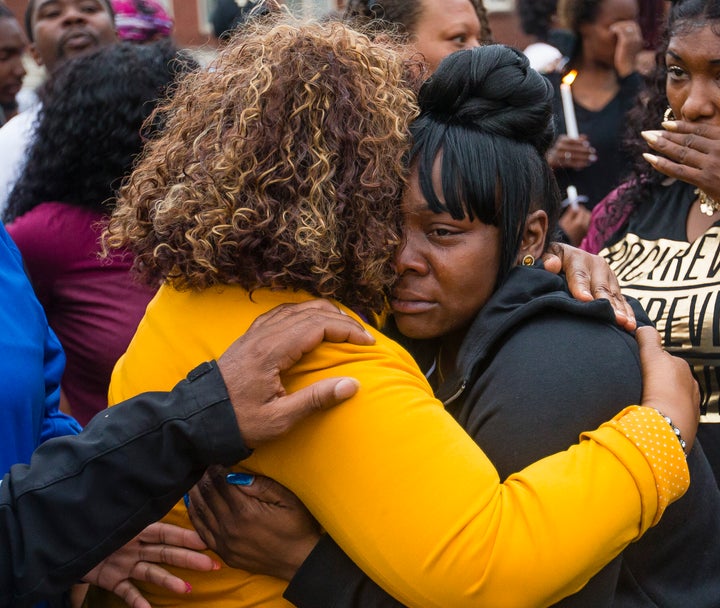 Family members embrace one another during a vigil for Eric Logan Monday, June 17, 2019, on Washington Street in South Bend, Ind.