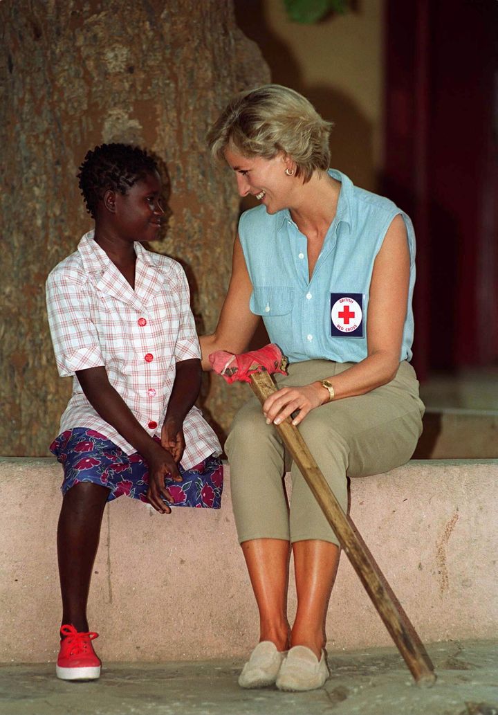 Princess Diana sits with 13-year-old Sandra Thijika, who lost her leg to a landmine, at Neves Bendinha Orthopaedic Workshop in Luanda, Angola.