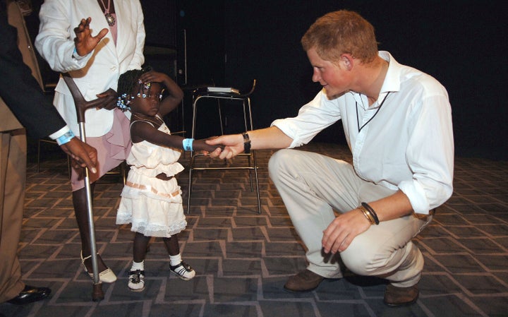 Prince Harry shakes hands with 3-year-old Eufrafina, at the Concert for Diana at Wembley Stadium on June 30, 2007. Eufrafina is the daughter of Sandra Thijika, a land mine victim who met Princess Diana in 1997.