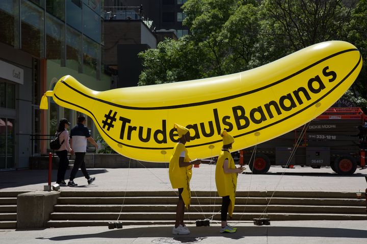 Two people dressed as bananas stand in front of a giant inflatable banana in downtown Ottawa on June 18, 2019. The PR stunt is a paid campaign launched by conservative advocacy group, Canada Proud.
