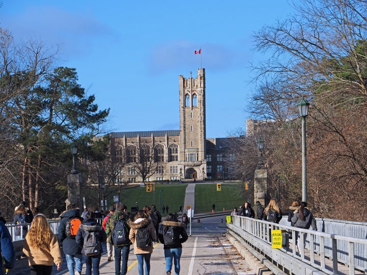 Students walking toward the gothic tower of University College at Ontario's Western University on Dec. 4, 2018.