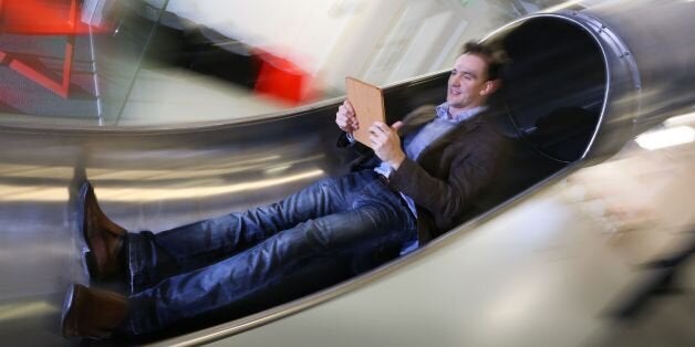 James Avery, manager at the Works in Folkestone, Kent, an innovative business hub, checks his tablet computer as he travels between the floors