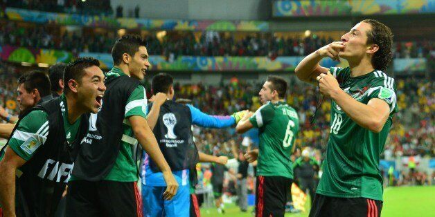 Mexico's defender Andres Guardado (R) celebrates with Mexico's midfielder Jose Juan Vazquez after scoring the 0-2 during a Group A football match between Croatia and Mexico at the Pernambuco Arena in Recife during the 2014 FIFA World Cup on June 23, 2014. AFP PHOTO / YURI CORTEZ (Photo credit should read YURI CORTEZ/AFP/Getty Images)