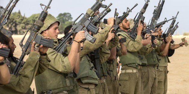 Israeli soldiers check their weapons at an army deployment area, on the southern Israeli border with the Gaza Strip, on August 1, 2014, after the proposed three-day truce that began at 0500 GMT collapsed amid a deadly new wave of bloodshed and the apparent capture of an Israeli soldier by Hamas. AFP PHOTO / JACK GUEZ (Photo credit should read JACK GUEZ/AFP/Getty Images)