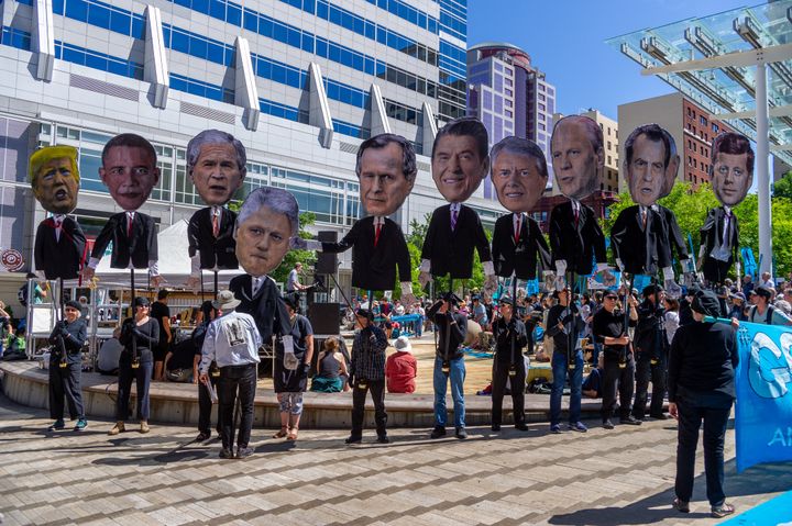 Past U.S. presidents are held up at a rally in Portland in support of a Supreme Court case in which young people are suing th