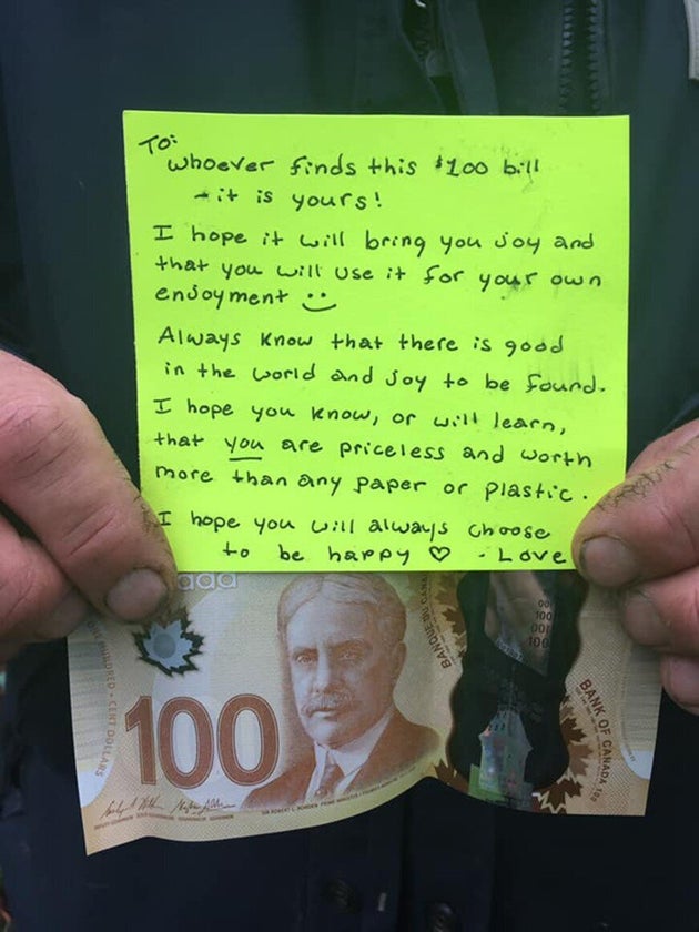 A person holds up a note and $100 bill anonymously placed in a park in New Glasgow,