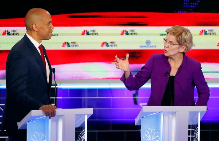 Sen. Elizabeth Warren talks with Sen. Cory Booker during the first Democratic primary debate. The 2020 presidential candidates largely stuck to their progressive stances.