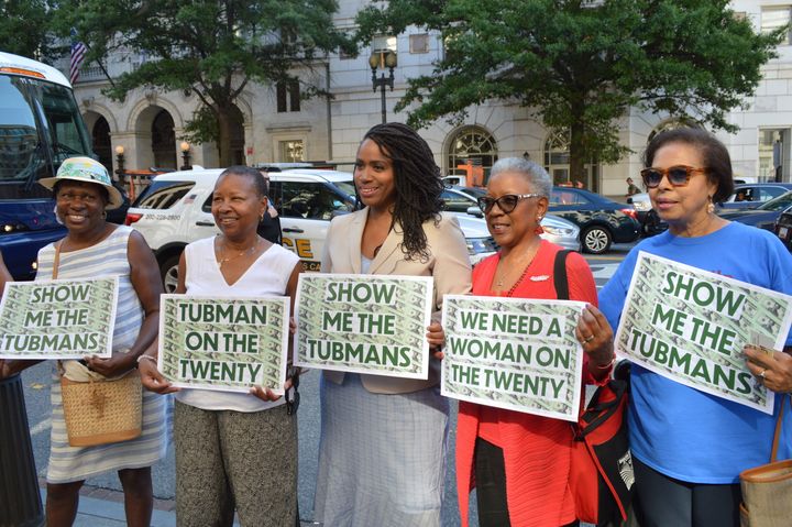 Rep. Ayanna Pressley (D-Mass.), center, holds up signs with supporters that call for Harriet Tubman to be put on the $20 bill at a press conference on Thursday.