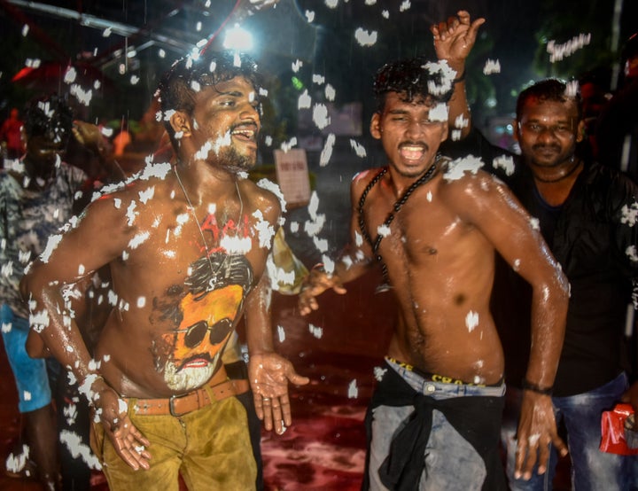 Fans of Bollywood actor Rajinikanth displaying body paint with a portrait of the actor as they dance on the first day of release of his new film Kaala in Mumbai.
