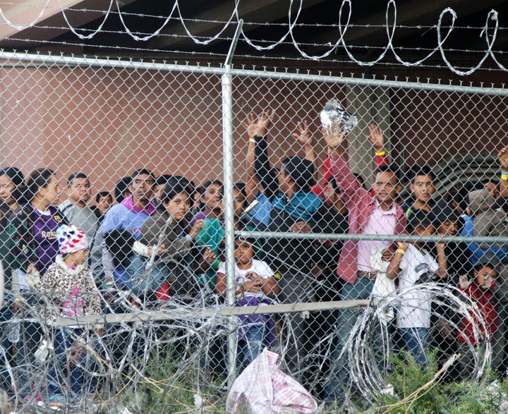 Central American adults and children stand imprisoned in a pen erected by U.S. Customs and Border Protection in El Paso, Texas, on March 27, 2019. 