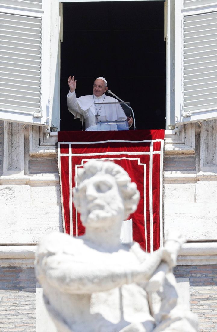 Pope Francis waves to the faithful during the traditional Angelus prayer from the window of his studio overlooking St. Peter's Square at the Vatican on Sunday.