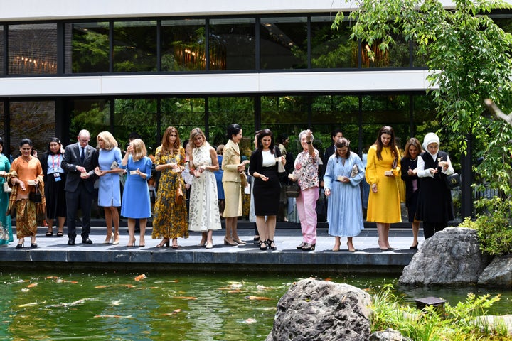 Las mujeres (y el marido de Theresa May) de los líderes mundiales dan de comer a los peces.