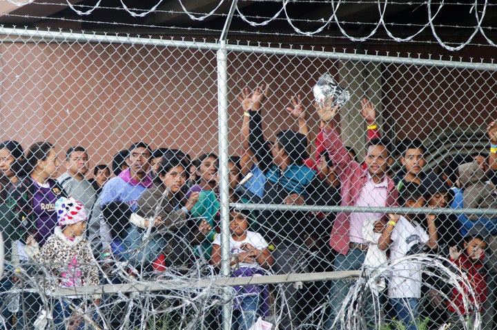 In this March 27, 2019, file photo, Central American migrants wait for food in a pen erected by U.S. Customs and Border Prote