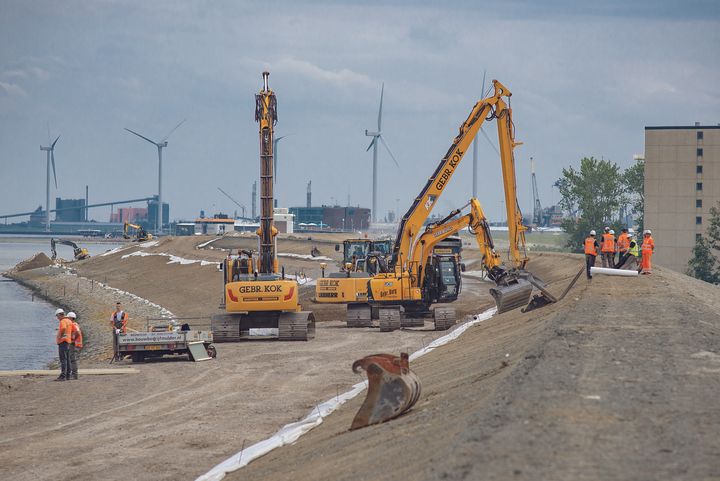 Construction workers raise a 12 kilometer stretch of a sea dike by 2 meters to meet new safety standards made necessary by sea level rise, near Delfzijl in the Netherlands.
