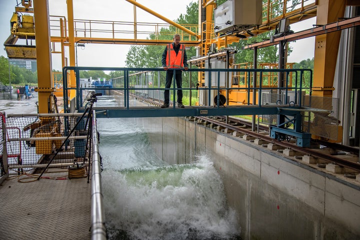 A researcher at the The Deltares Research Institute in Delft runs a test in the Delta Flume, a 300 meter-long wave machine. He is examining a new type of material for use in sea dikes.