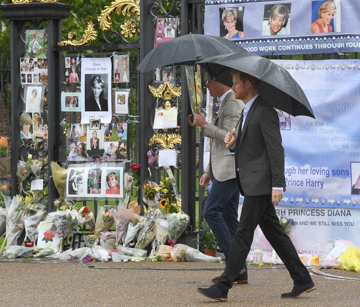 William and Harry look at tributes left by the public dedicated to their mother Princess Diana following their visit to The White Garden, in Kensington Palace on Aug. 30, 2017.