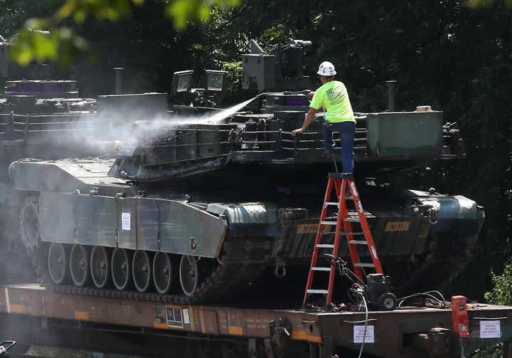 A worker washes one of two M1A1 Abrams tanks that are loaded on rail cars July 2 in Washington, D.C.