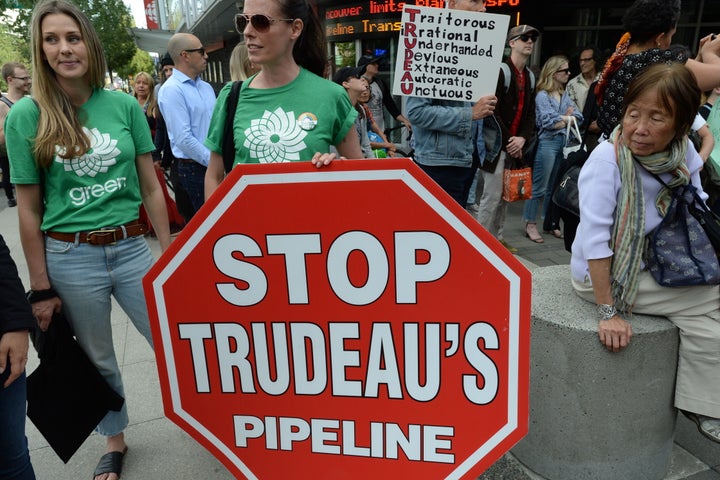 Protesters, including Bridget Burns, the federal Green Party candidate for Vancouver East, centre, and her campaign manager, Alex Brunke, left, take part in a demonstration against the Trans Mountain pipeline expansion in downtown Vancouver on June 18.