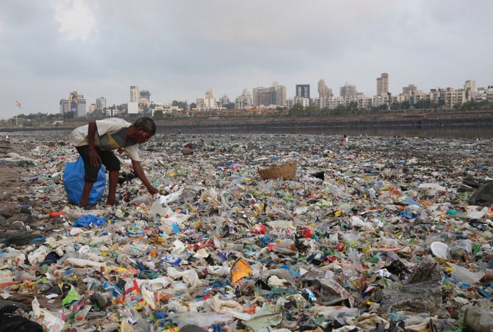 A man collects plastic and other recyclable material from the shores of the Arabian Sea, littered with plastic bags and other garbage, in Mumbai, India, in June of 2018.