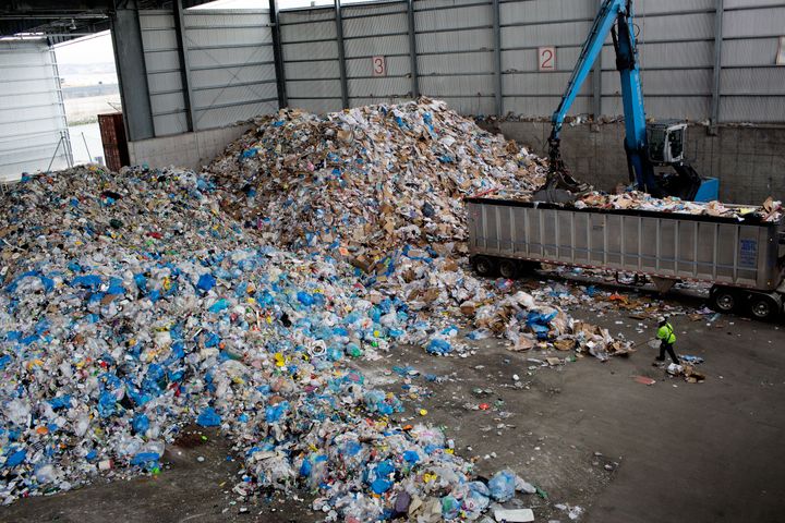 Workers collect recycled trash in Brooklyn, New York, as New York City Mayor Bill De Blasio held a press conference at a city recycling center processing plant where he signed a bill that would ban single-use plastics.