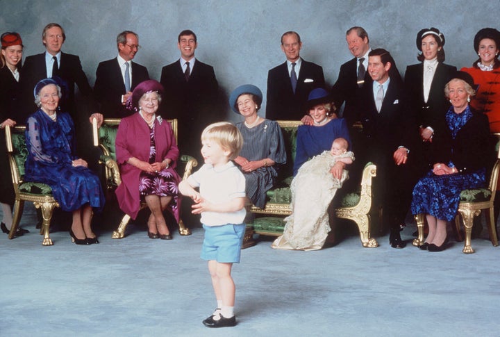 Prince William steals the show at Prince Harry's christening at Windsor Castle on December 21, 1984, with relatives and godparents in the background.