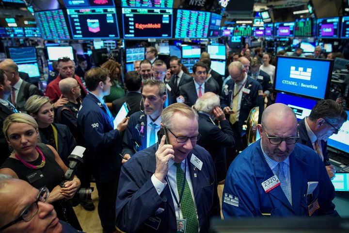 Traders gather around a post as they wait for the start of the trading day at the New York Stock Exchange, June 20 in New York City.