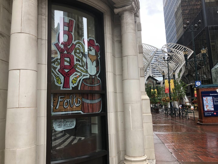 A penguin says "howdy folks" on the outside of a Calgary bank.