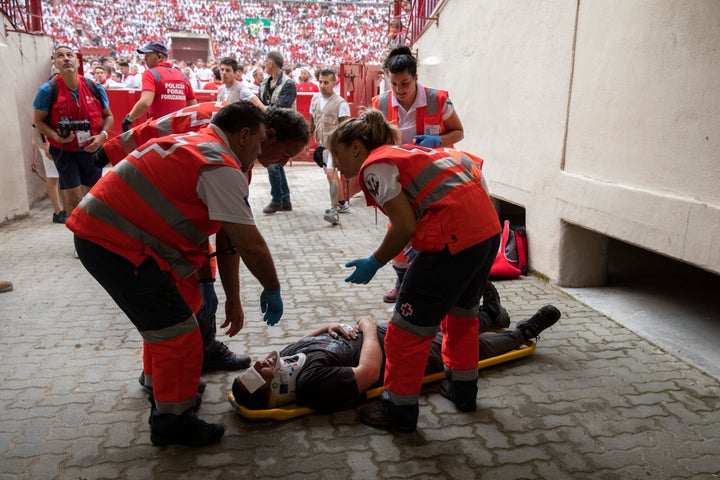 Paramedics prepare to take unidentified man to the hospital after the running of the bulls.