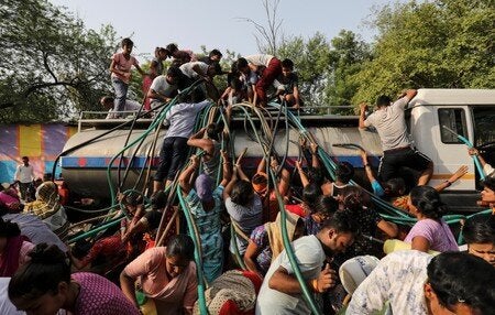 Residents fill their containers with drinking water from a municipal tanker in New