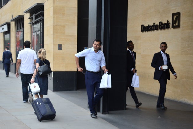 People outside a London office of Deutsche Bank which has confirmed plans to cut 18,000 positions across its global business, causing thousands of workers in the City of London to fear for their jobs