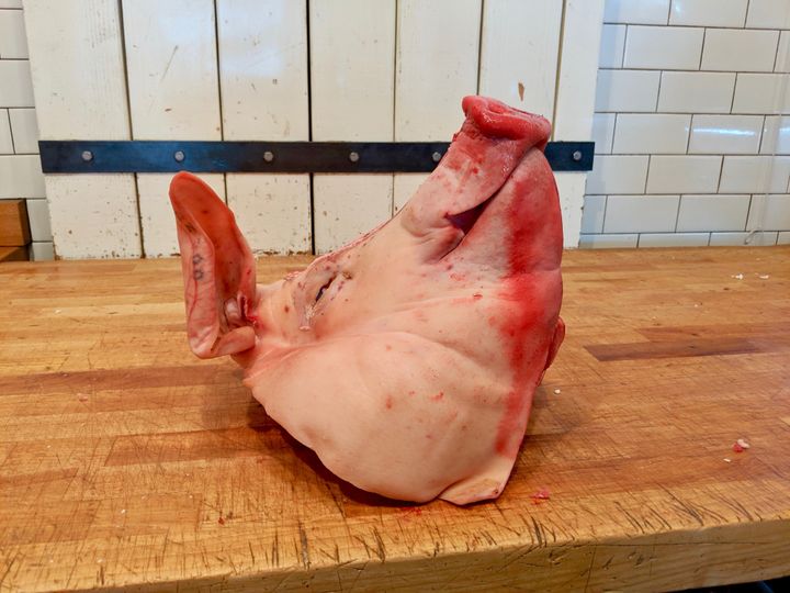 A pig's head sits on the butcher block before being turned into head cheese at Western Daughters in Denver.