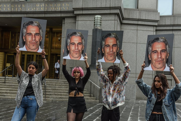 Members of a protest group called "Hot Mess" hold up signs of Jeffrey Epstein in front of the federal courthouse on July 8, 2019, in New York City.