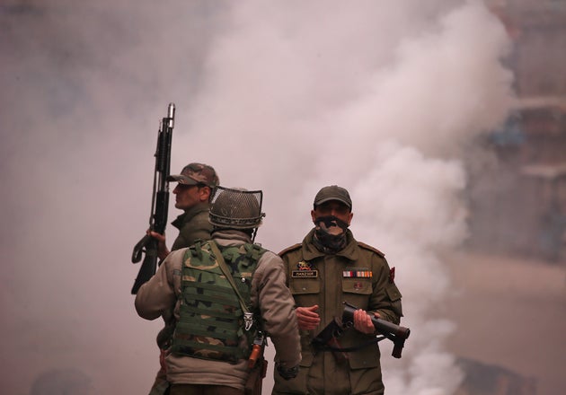 A police officer prepares to load his tear gas gun during a protest in Srinagar on 26 February