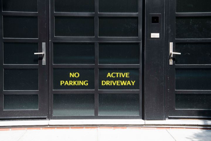 Signs on the back entrance to Noam Gottesman's complex read "No Parking" and "Active Driveway."