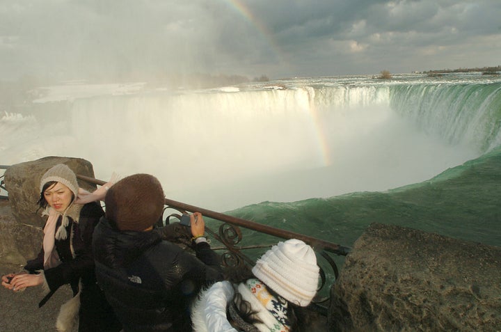 Tourists look over the brink of the Horseshoe Falls at Niagara Falls, Ontario, near where a man plunged over the falls and survived in 2009.