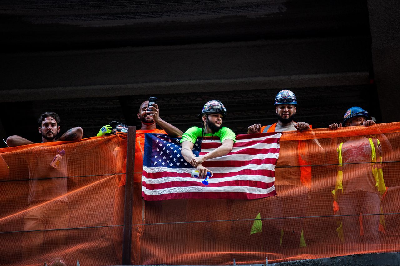 Construction workers watch the parade.