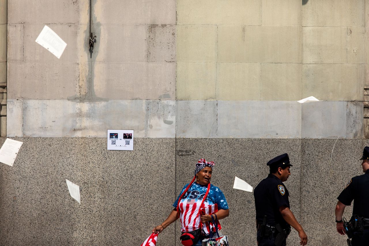 A woman walks along the parade route as papers and ticker tape falls. 