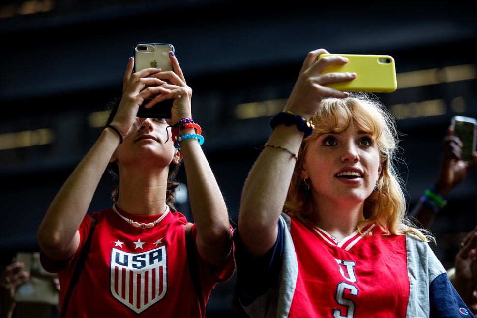 Fans take photos along the parade route.