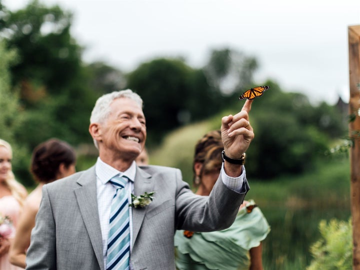 A monarch butterfly clings to Max's father.