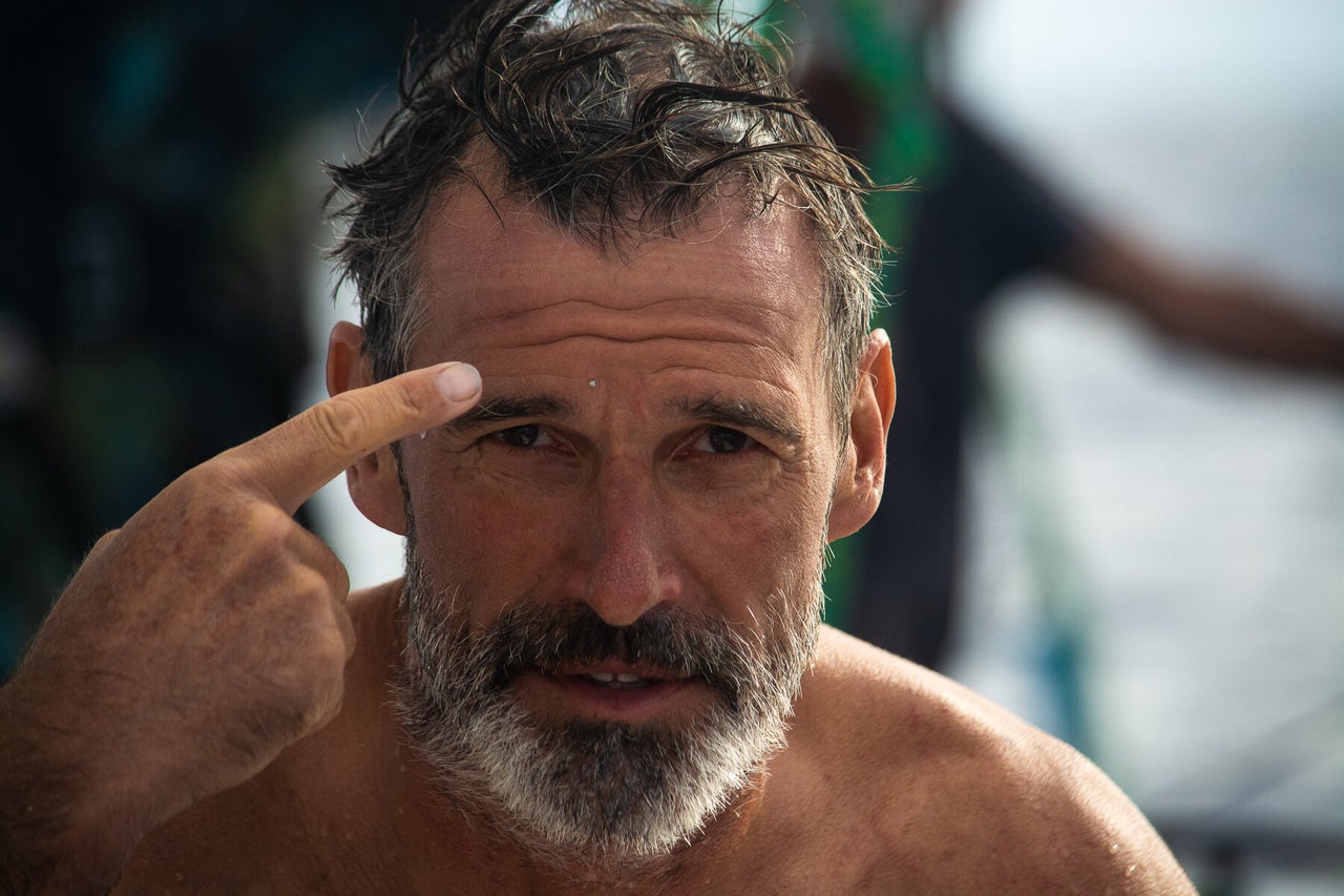 Lecomte emerges from the water with a piece of plastic stuck to his forehead.