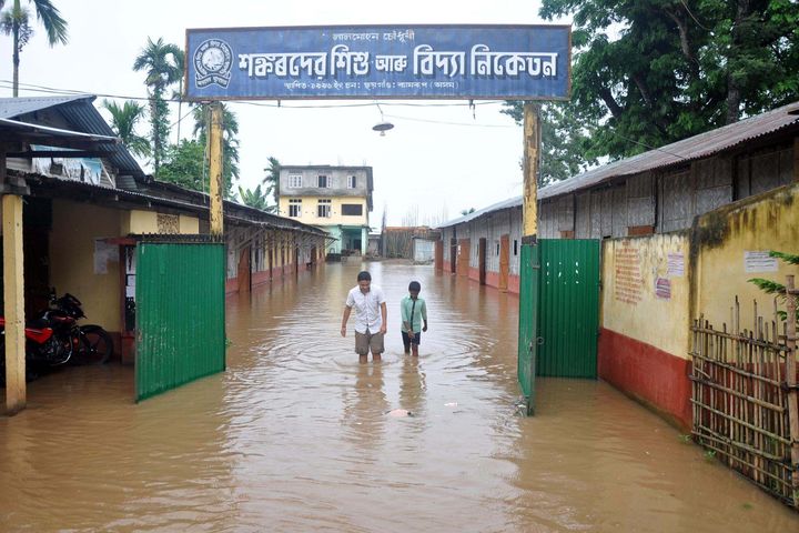 School students outside their partially submerged school at Chhaygaon in Kamrup District of Assam on 10 July 2019.