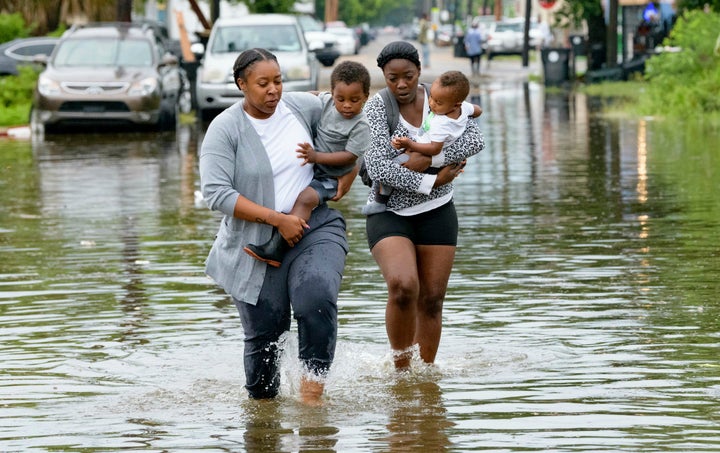 Jalana Furlough carries her son Drew Furlough as Terrian Jones carries Chance Furlough in New Orleans after flooding Wednesda