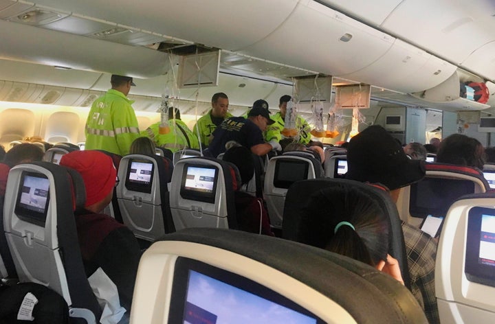 First responders are seen here treating a passenger on an Air Canada flight to Australia that was diverted on Thursday due to turbulence.