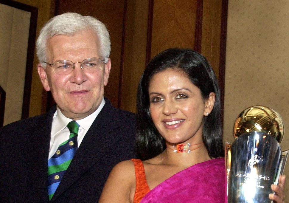 Mandira Bedi poses with the ICC Champions Trophy, as the CEO of ICC Malcolm Speed looks on in Bombay in 2004. 