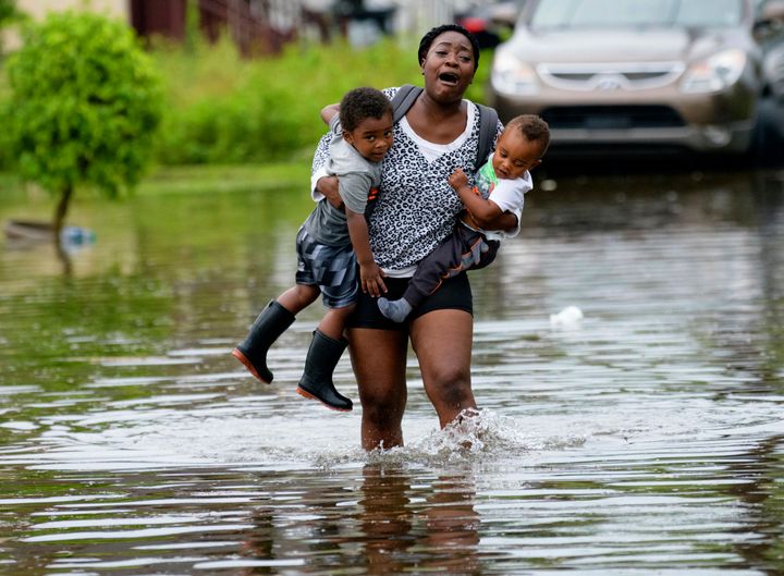 Terrian Jones reacts as she feels something moving in the water at her feet as she carries Drew and Chance Furlough to their mother on Belfast Street in New Orleans during flooding earlier this week. 